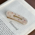 Fermaglio per capelli ovale crema con strass colorati su sfondo di pagine di libro - Bianco trasparente