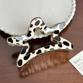 Star-shaped hair claw clip featuring a classic black and white cow print pattern - Star Style