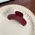 Elegant matte burgundy shark hair claw clip displayed on a vintage ceramic plate - Red Curved - 8.3cm