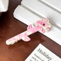 Pink marble acetate flower hair clip with rhinestone center on a minimalist display - Pink