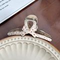 Elegant cream bow hair claw with brown polka dots and acetate finish on wooden desk - Coffee Polka Dot Medium
