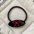 Elastico per capelli marrone con ciondolo in resina nera e fiocco di strass rossi - Piccolo / Nero