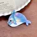 Irisierende hellblaue Delphin-Haarklammer aus Acetat auf einem Holztisch mit Teller - Delfin-Stil