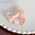 Pink and white acetate bow hair clip with an iridescent finish on a ceramic plate - Pink White Marble Hair Clip