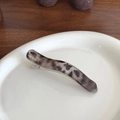 Elegant tortoise shell patterned hair clip with a wavy design on a ceramic plate - Leopard Print