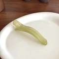 Translucent light green duckbill hair clip with jelly texture on white ceramic plate - Green