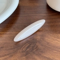 Minimalist cream white acetate hair clip with glossy pearl finish on dark wood table - Milky White
