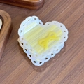 Acetate heart hair claw with bow and cream marble texture on a wooden surface - Yellow Striped