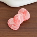 Rosafarbene Haarklammer aus Acetat in Schleifenform mit Marmormuster auf Holztisch - Rosa