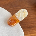 Haarklem in capsulevorm met amber marmeren textuur en kleine bloemsteentjes - Koffie Witte Pil