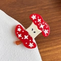 Pince à cheveux champignon rouge avec étoiles blanches et yeux sur support blanc - Trognon de pomme rouge