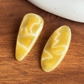 Set di due fermagli per capelli in resina gialla con elegante trama marmorizzata e ondulata - Giallo