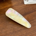 Lichtgele iriserende druppelvormige haarclip met parelmoerglans op houten achtergrond - 5.6cm / Iriserend Wit