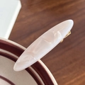 Elegante pinza de pelo ovalada de resina crema con textura jaspeada y base de metal dorado - 5.9cm / Blanco