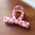 Cute pink bow claw clip with fuchsia cat paw prints on a textured wooden background - Pink-Bow