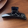 Close-up of black glossy hair claw with white heartbeat and heart pattern design - Black Scribble 11.6cm