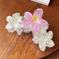 Detail of floral hair claws in pink yellow gradient and transparent floral patterns - Pink