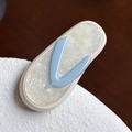 Eleganter ovaler Acetat-Haarclip in Perlweiß mit einem blauen V-förmigen Akzent - Cremeweiß