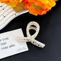 Detail of white marble pattern hair claw clip with a glossy finish and gold metal spring - Floral Beige Small