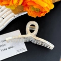 Close-up of a large marble texture hair claw clip with cream pearlescent finish and metal spring - Floral Beige Large