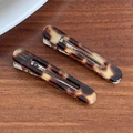 Set mit zwei Vintage Haarklammern aus Acetat mit Schildpattmuster auf Holzgrund - Braun