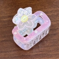 Viereckige Haarklammer in Pink-Lila mit Blume und gelbem Smiley auf Holzoberfläche - Metallrosa