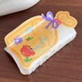 Cremeweiße Haarklammer mit süßer Krabbe und Schleife auf einem dunklen Holztisch - Gelb