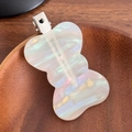 Iridescent white acetate wavy hair clip with metal duckbill clasp on wooden surface - Iridescent White