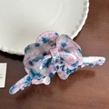 Detail view of pink and blue marbled acetate butterfly hair claw clip on wooden surface - Pink-Blue Marble