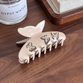 Elegante pinza per capelli a farfalla rosa con strass su superficie in legno - Beige