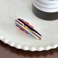 Nahaufnahme einer wellenförmigen Haarklammer aus Acryl mit bunten Streifen auf einem Tablett - Mittel / Regenbogenstreifen