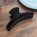 Minimalist large black flocked hair claw clip with velvet finish on a wooden background - Black Semicircle