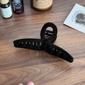 Grande molletta per capelli nera con finitura floccata opaca su un tavolo in legno - Nero (Stile Nastro)