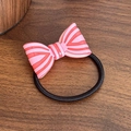 Pink striped bow hair tie with black elastic band shown on a dark wooden table - Pink Orange Hair Tie