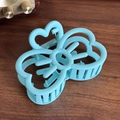 Pinza per capelli a farfalla azzurro opaco con cuori su fondo di legno scuro - Blu