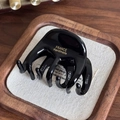 Glossy black acetate hair claw clip with gold France Handmade logo on a wooden tray - Black