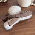 Plüschige Haarklammer in Creme mit brauner Schleife auf rustikalem Holzhintergrund - Beige