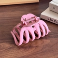 Pink matte pumpkin hair claw clip with wavy teeth design on dark wooden table - Rose Red