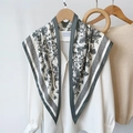 Elegant floral print silk scarf in grey styled over a white shirt on wooden hanger - 87x130cm / Gray