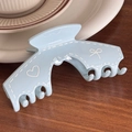 Light blue trapezoid hair claw clip with white heart and bow graffiti patterns - Blue Arch Shape