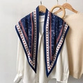 Blauwe zijden sjaal met geometrische print op een wit overhemd en houten kledinghanger - Blauw