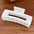 Matte white rectangular silicone hair claw clip shown on a wooden textured background - Square-White