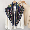 Detail van een zijden sjaal met bloemen en tropische bladeren op een wit overhemd - Blauw