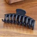 Matte black large hair claw clip made of soft silicone on a dark wooden background - Shark Clip-Black