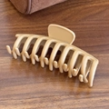 Matte cream large silicone shark hair claw clip for thick hair shown on wooden desk - Shark Clip-Light Coffee