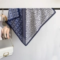 Elegante zijden sjaal in marineblauw en wit met bloemenprint gepresenteerd op hanger - 68*68cm / Blauw