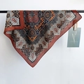 Close-up detail of vintage bohemian printed square scarf with mandala patterns and fine texture - Red