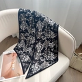 Detail eines Seidenschals mit weißem Blumendruck auf schwarzem Grund mit Spitzen - Kleines Schwarzes Blumenmuster