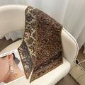 Détail d'un foulard en soie à motif paisley marron et doré drapé sur une chaise chic - Paisley Jaune Terre