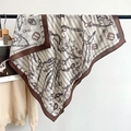 Détail de la texture soyeuse et du motif de chaîne et ceinture sur l'écharpe de luxe - Marron / 90x90cm